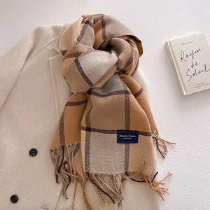 Detailed shot of classic checkered cashmere scarf with fringe and elegant woven label
