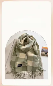 Nahaufnahme von grün-beige kariertem Kaschmirschal mit Fransen auf Wollsakko