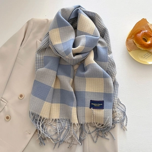 Nahaufnahme von blau-beige kariertem Kaschmirschal mit Fransen und elegantem Webetikett
