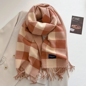 Detail von kariertem Kaschmirschal mit Fransen auf Blazer, zeigt weiche Strickstruktur