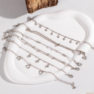 Detail of 6-piece silver charm bracelet set with stars, hearts, and pink pearls