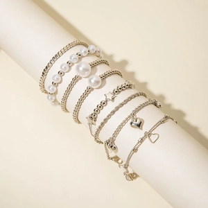 Detail of seven-piece silver-toned bracelet set with pearls, stars, and heart charms