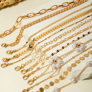 Detailed view of six-piece golden link bracelet set with heart charms and pearls