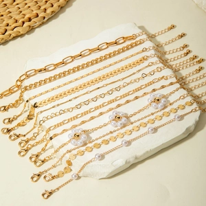 Détail d'un ensemble de 10 bracelets dorés avec breloques cœur, étoile et perles
