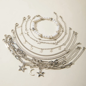 Detailed view of silver charm bracelet set with star and moon pendants and white pearls