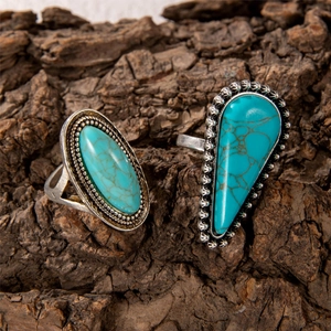 Detail of vintage turquoise petal rings with engraved silver plating on tree bark background