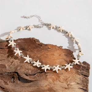 Detail of bohemian starfish beaded necklace with shell charms on a wooden background