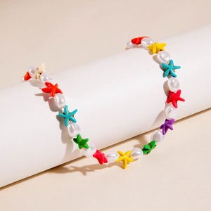 Detail of bohemian necklace with white pearls and multi-colored starfish beads on a stand