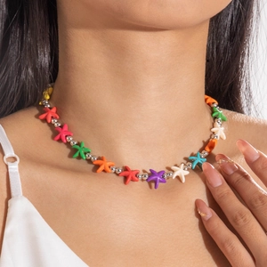 Detailed view of colorful starfish beads and silver metal spacers on a layered necklace