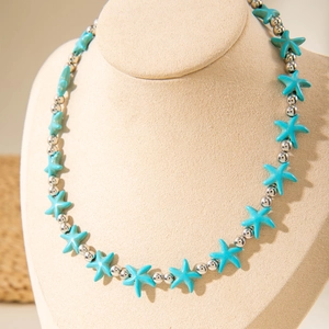 Detailed shot of turquoise starfish beads and silver metal spheres on a bohemian necklace