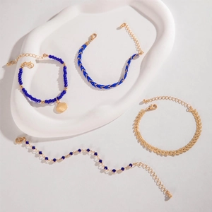 Detailed close-up of bohemian blue bead and gold shell multi-layer bracelet set