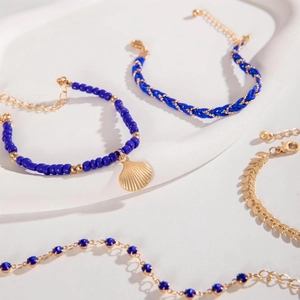 Detailed shot of bohemian multi-layer bracelets featuring blue beads and shell charms