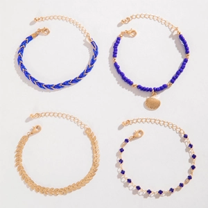 Bohemian multilayer bracelet set with blue beads, shells and gold leaves on white base