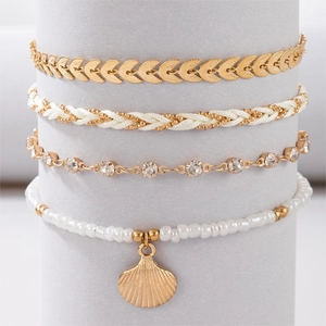 Detail of bohemian multilayer bracelet set with gold shell charm and beaded weave
