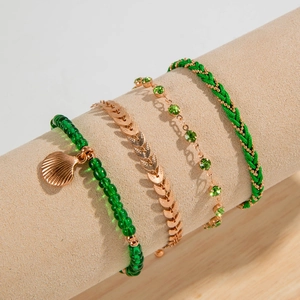 Detail of four-piece Bohemian bracelet set with green beads and rose gold shell charm