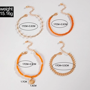 Detail view of bohemian multi-layer bracelets featuring shell charms and orange bead cords