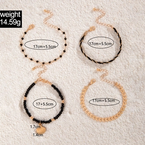 Detail view of Bohemian layered bracelet set with black beads, shell charms and leaf pendants