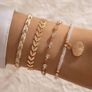 Bohemian multilayer bracelet set featuring shell charms, gold leaf links and beads