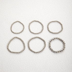 Detail of six-piece silver beaded stretch ring set for layering and stackable industrial style