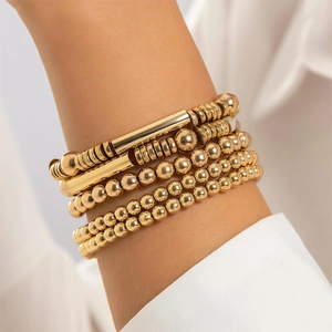Minimalist five-piece gold beaded bracelet set with high-polish metal tubes and heart charm