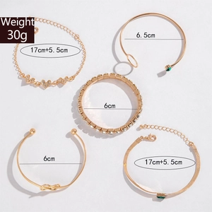 Detailed view of 5-piece gold bracelet set with green gemstones and rhinestones