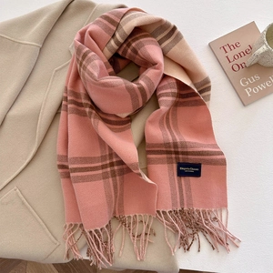 Pink and beige striped plaid scarf with fringe on a beige coat with books