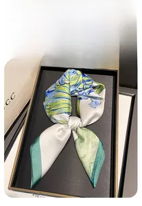 Dettaglio di un foulard in seta 70cm con stampa iris verde acqua in vassoio elegante