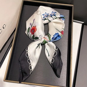 Dettaglio di un foulard di seta con motivi floreali su un vassoio decorativo nero