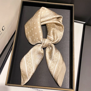 Dettaglio di foulard in seta champagne con pois bianchi e motivi floreali eleganti