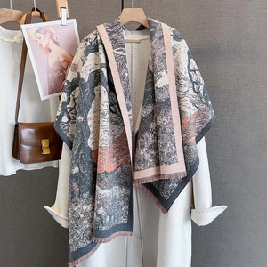 Close-up of pink tassel fringe and intricate floral jacquard weave on winter scarf