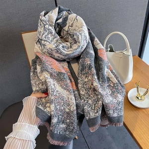Close-up of winter jacquard scarf with artistic landscape pattern and tassel details