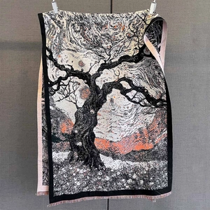 Close-up of intricate floral jacquard texture and orange sunset pattern on warm scarf