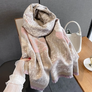 Detail of soft winter scarf with pink marble pattern and delicate fringe tassels