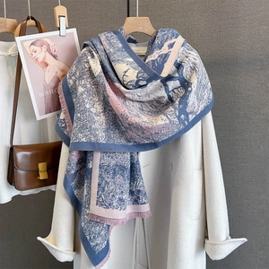 Detail of blue and pink jacquard scarf with fine fringe on a white autumn coat