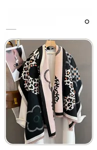 Dettaglio della sciarpa in finto cashmere con motivi floreali, leopardati e frange