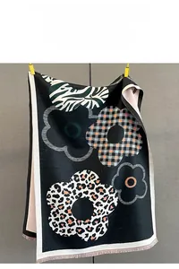 Dettaglio di sciarpa jacquard con motivi leopardati, zebrati e floreali con frange