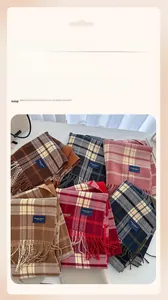 Detail of multi-color plaid scarves with tassel edges and elegant classic woven labels