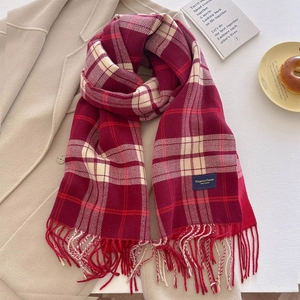 Soft red plaid tassel scarf with cashmere feel, displayed on an apricot coat
