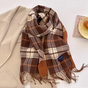 Detail of thick plaid scarf with fringe on wool coat and lifestyle props