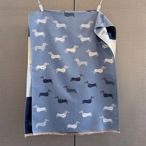 Détail macro d'une écharpe en cachemire bleu avec motif teckel et bords à franges