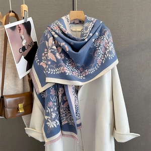 Close-up of floral jacquard pattern and soft fringe on navy blue winter scarf