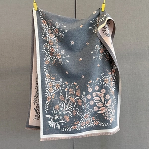 Detailed close-up of thick floral cashmere scarf with elegant tassels and flower patterns