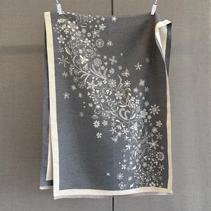 Détail du châle en tricot à motif floral avec pompons élégants et texture douce