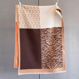 Detail of jacquard scarf showing leopard zebra patchwork print and soft white tassels