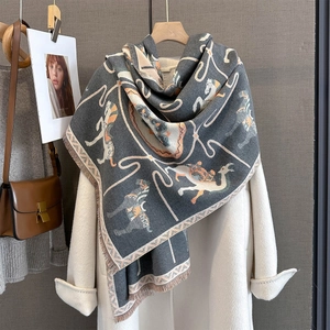 Dark grey animal pattern shawl with tassels styled on a white coat for autumn winter
