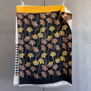 Detailed view of winter cashmere scarf with ginkgo leaf patterns and houndstooth edge
