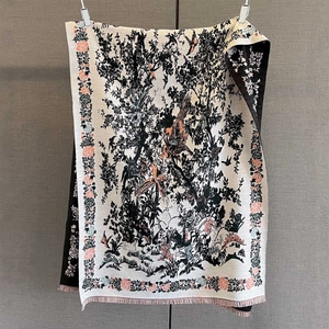 Close-up of vintage floral and bird patterns on a cashmere-style winter scarf with tassels
