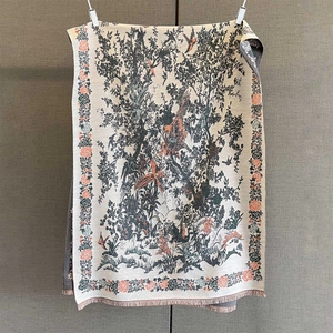 Close-up of vintage flower and bird print scarf with delicate fringe tassels and knit texture