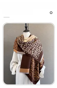 Detail of leopard and zebra pattern jacquard scarf with frayed edges in coffee and beige