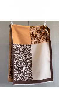 Detail of leopard and zebra pattern jacquard scarf showing thick fringe and fine texture